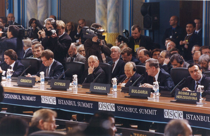 Photo of the OSCE Istanbul Summit, showing diplomats, country representatives, and media capturing the high-level discussions.