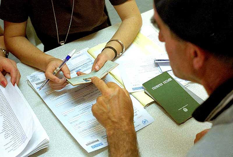 Person reviewing documents and passports at a registration desk.